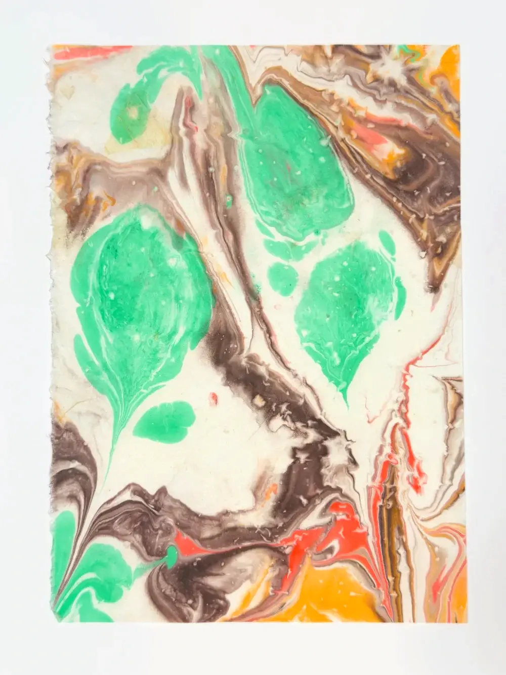 Green leaf-shaped drops with brown and orange swirls on white