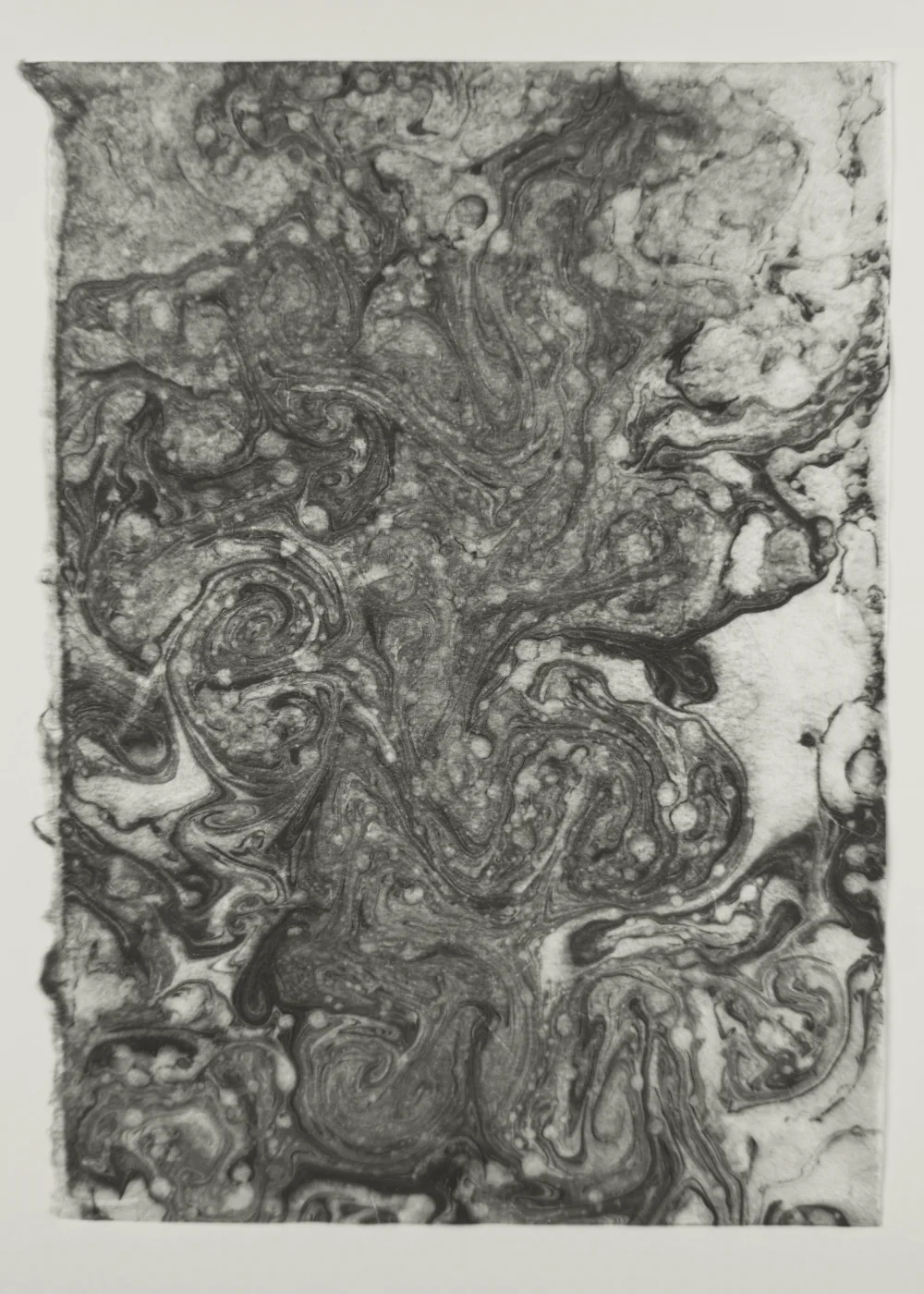 Suminagashi monotype with bold black ink forms breaking apart