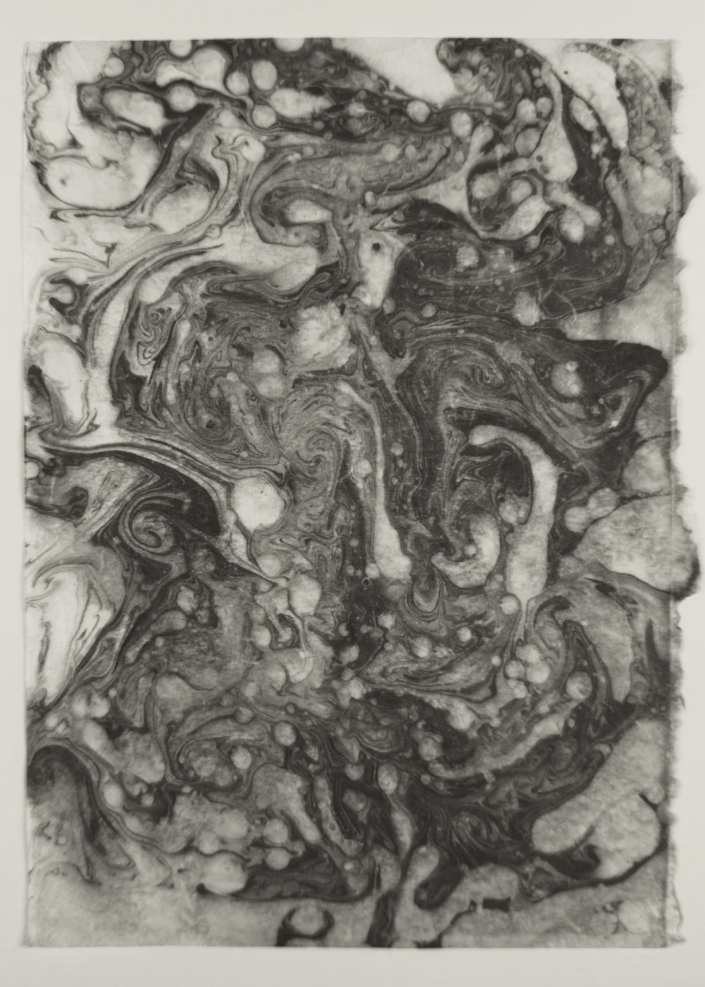 Black and white suminagashi monotype with layered fluid structures