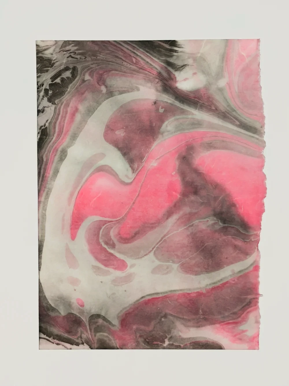 Paper marbling monotype with layered translucent rings and warm tones, left half
