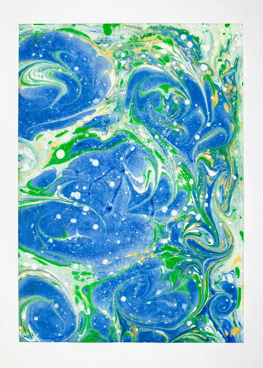 Curling blue paisley forms on pale ground, green and white threads between them with faint gold flecks